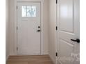 Bright entryway featuring a white front door with glass panes and black hardware, complemented by light wood flooring at 823 32Nd Ne St, Conover, NC 28613
