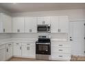 Well-lit kitchen boasts white cabinets, stainless steel appliances, and modern black hardware, creating a sophisticated look at 823 32Nd Ne St, Conover, NC 28613