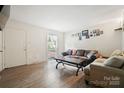 Bright living room boasting laminate wood floors, a large window, and cozy seating arrangement at 924 Carrington Dr, Charlotte, NC 28214