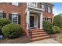 Welcoming front entrance with brick steps, black railings, and a decorative wreath on the front door at 9717 Waterton Ct, Huntersville, NC 28078