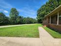 Brick home featuring green lawn with mature trees on a sunny day at 10414 Tillman Steen Rd, Indian Land, SC 29720