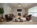 Cozy living room featuring a fireplace, hardwood floors, and comfortable leather seating at 11021 Travis Gulch Dr, Charlotte, NC 28277