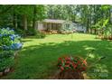 Lush backyard featuring mature trees, manicured lawn, and vibrant flower arrangements at 116 April Ln, Dallas, NC 28034