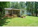 Spacious backyard with a screened-in porch, lush lawn, and mature trees for privacy at 116 April Ln, Dallas, NC 28034