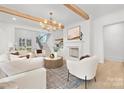 Open-concept living room with wood beams, fireplace, modern lighting, and comfortable seating at 1321 Ferncliff Rd, Charlotte, NC 28211