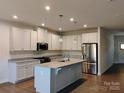 Bright and modern kitchen features an island, granite counters, and stainless steel appliances at 1598 Respect St, Concord, NC 28027