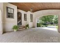 Attached carport with brick flooring and wood ceilings leading to the front door at 1728 Shadow Forest Dr, Matthews, NC 28105