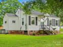 Attractive house with vinyl siding, black shutters, and a lush green lawn, creating a welcoming atmosphere at 206 Charlotte St, York, SC 29745