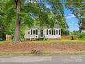 Cozy home with a brick foundation, black shutters, and a front yard featuring mature trees and street view at 206 Charlotte St, York, SC 29745