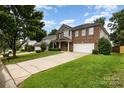 Suburban two-story brick home with well-maintained lawn and long driveway on a sunny day at 237 Lylic Woods Dr, Fort Mill, SC 29715
