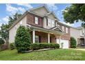 Attractive two-story brick home with covered porch, neat landscaping, and attached two-car garage at 237 Lylic Woods Dr, Fort Mill, SC 29715