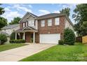Traditional two-story brick home featuring manicured landscaping and an attached two-car garage at 237 Lylic Woods Dr, Fort Mill, SC 29715