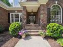Inviting front entrance with brick steps, decorative plants, and elegant wrought iron railings at 2616 Carmarthen Ct, Matthews, NC 28104