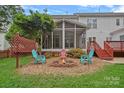 Inviting backyard featuring a cozy fire pit area with colorful Adirondack chairs and a spacious screened porch at 3830 Waters Reach Ln, Indian Trail, NC 28079