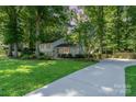 A beautifully landscaped home with a long driveway and lush green lawn at 4014 Sulkirk Rd, Charlotte, NC 28210