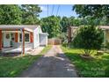 View of the driveway leading up to the home, between fenced neighboring property at 405 E 18Th St, Kannapolis, NC 28083