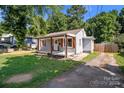 Single-story home featuring a welcoming front porch, shuttered windows, and a driveway at 405 E 18Th St, Kannapolis, NC 28083