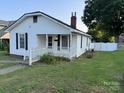 Quaint single-story home featuring white siding, black shutters and a well-kept front yard at 407 W Mill St, Landis, NC 28088