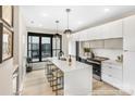 Modern kitchen boasts white cabinets, quartz countertops, stainless steel appliances, and sleek pendant lighting at 411 Devender Ne Ln # 5, Charlotte, NC 28217