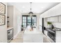 Modern kitchen boasts white cabinets, quartz countertops, stainless steel appliances, and sleek pendant lighting at 411 Devender Ne Ln # 5, Charlotte, NC 28217