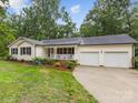 Charming home features a front porch, manicured lawn, and a two-car garage with driveway at 5322 Bridgeview Dr, Iron Station, NC 28080