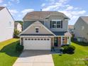 Charming two-story home featuring a stone facade and attached garage with a well-manicured lawn at 6156 Kilchurn Dr, Fort Mill, SC 29707