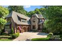 Brick and stone home showcasing well-maintained landscaping, a three car garage, and a classic design at 617 Beauhaven Ln, Waxhaw, NC 28173