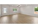 Bright living room featuring wood-look floors, white walls, recessed lighting, and natural light from large windows at 7311 Jerimoth Dr, Charlotte, NC 28215