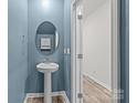 Stylish powder room featuring a modern pedestal sink and a serene blue accent wall at 853 Gerard Bay Dr, Fort Mill, SC 29715
