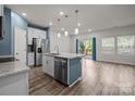 Open-concept kitchen featuring stainless steel appliances and a spacious island with granite countertop at 853 Gerard Bay Dr, Fort Mill, SC 29715