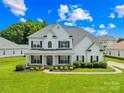 Beautiful two-story home featuring a lush green lawn and classic architectural details at 112 Doyle Farm Ln, Mooresville, NC 28115
