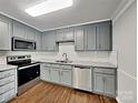 Modern kitchen featuring stainless steel appliances, granite countertops, subway tile backsplash, and gray painted cabinetry at 120 Todd Nw Dr, Concord, NC 28025