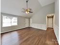 Spacious living room with a vaulted ceiling, a ceiling fan, and stylish wood-look floors creates a welcoming ambiance at 120 Todd Nw Dr, Concord, NC 28025