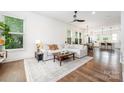 Bright living room with hardwood floors, large windows, and an open layout to kitchen at 1207 E 36Th St, Charlotte, NC 28205