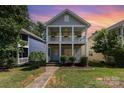 Charming two-story home with double front porches, bright blue door, and lush landscaping at 12304 Huntersville Concord Rd, Huntersville, NC 28078