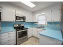 Functional kitchen featuring white cabinets, stainless steel appliances, and bright blue countertops at 1330 5Th Ne St, Hickory, NC 28601