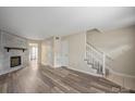 Spacious living room featuring wood-look floors, a fireplace, and staircase to the upper level at 1330 5Th Ne St, Hickory, NC 28601