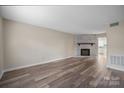Inviting living room featuring wood-look floors, a white brick fireplace, and an open floor plan at 1330 5Th Ne St, Hickory, NC 28601