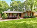Brick home featuring dark shutters and lush landscaping, offering a classic and inviting curb appeal at 13617 Lake Bluff Dr, Matthews, NC 28105
