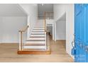 Bright foyer with hardwood floors, a staircase with wood banister, and a view into other rooms at 15400 Groveland St, Huntersville, NC 28078