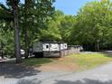 RV featuring a wooden deck with a fence around it, nestled in a peaceful wooded setting at 155 Indian Harbor Trl # E243, Mount Gilead, NC 27306