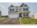 Charming two-story home with a one-car garage, front porch, and manicured lawn at 236 Paradise Dr, Belmont, NC 28012