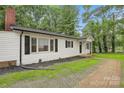 Exterior view of home with white siding, black shutters, brick foundation, and green grass at 240 Swink Ave, Salisbury, NC 28147