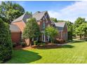 Attractive brick home showcases lush green lawn and meticulous landscaping, perfect for outdoor enjoyment at 2504 Fallbrook Pl, Concord, NC 28027