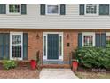 Inviting front entrance with a dark green door, brick facade, and decorative planters at 2917 Rustic Ln, Charlotte, NC 28210