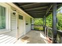 Inviting covered front porch featuring dark wood railings and a traditional white front door at 307 Elm St, Belmont, NC 28012