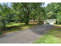 Traditional brick home with an asphalt driveway surrounded by lush green grass and a canopy of trees at 3230 Kingsfield Rd, Rock Hill, SC 29732