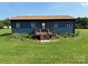 Cozy home showcasing a neatly maintained lawn and a welcoming front porch with steps at 490 County Line Rd, Stony Point, NC 28678