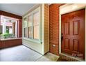 Inviting front porch with brick columns and a dark wood front door at 530 E 9Th St, Charlotte, NC 28202
