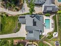 Aerial view of a home with a pool, patio, and lush landscaping at 5638 Timber Ln, Charlotte, NC 28270